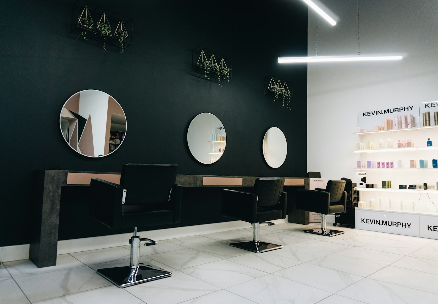 Three modern styling chairs in a clean, bright hair salon.