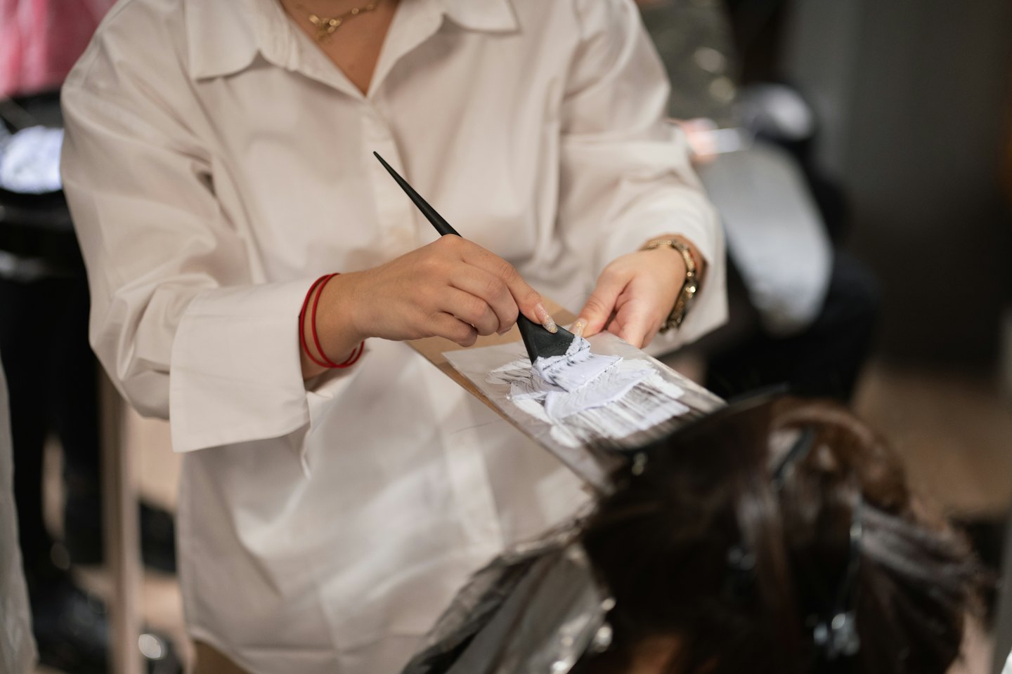Hair stylist mixing purple hair dye on a palette.